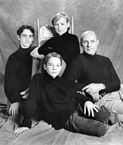 Studio portrait of family dressed in black tops and sitting on a