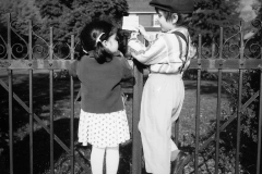 Outdoor Portrait of young boy and girl facing each other while r